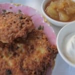 latkes on a plate with apple sauce and sour cream