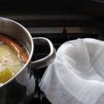 Straining chicken soup after it cooks.