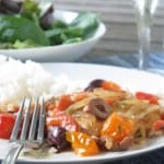 plate of chicken with roasted red pepper, olives and tomato