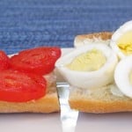 a baguette with slices of hard boiled egg and tomato