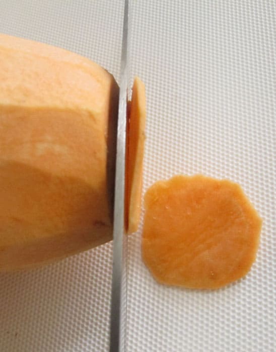 Slicing a sweet potato for baked sweet potato chips. 