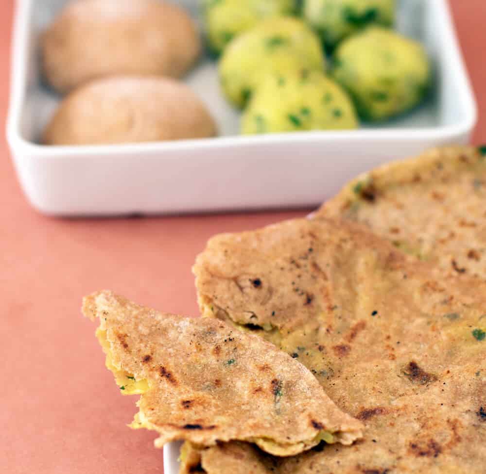 Aloo paratha, potato-filled flatbread, with the dough and filling behind.