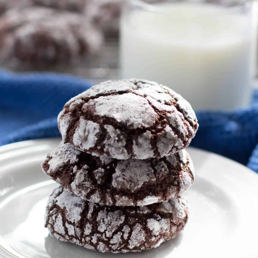 Stack of Fudgy Crackled Chocolate Cookies with a glass of milk | Mother Would Know