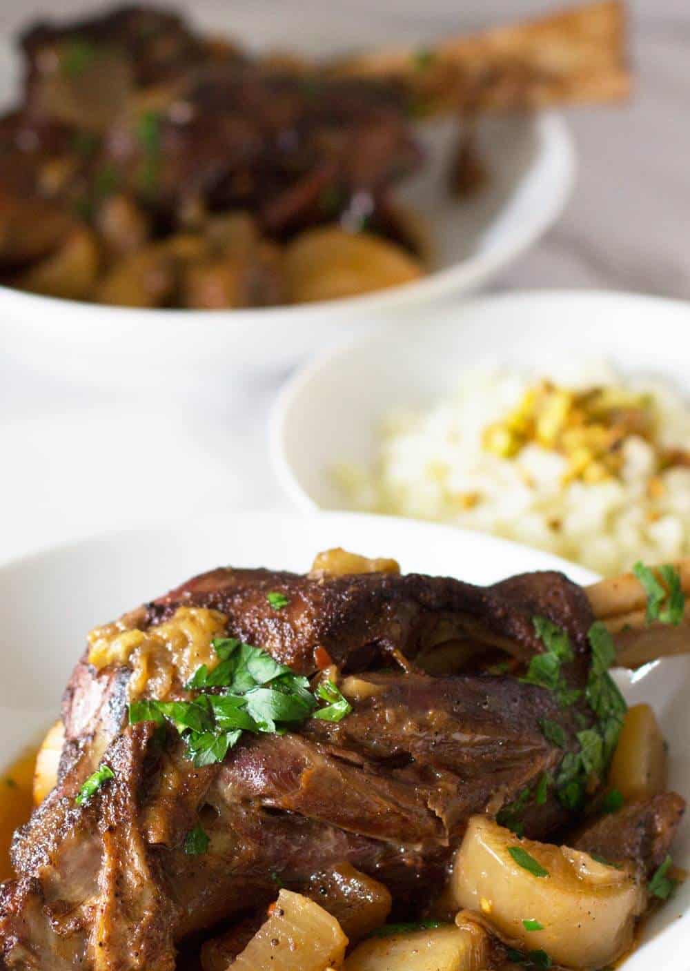 Indian-Style Keto Lamb Shanks, in bowls with bowl of cauliflower rice