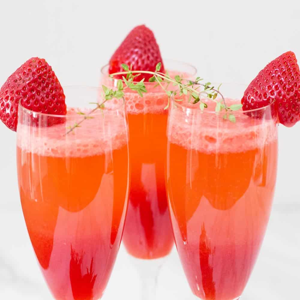 triangle of champagne flutes with starwberry bellini