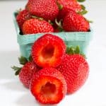 hulled strawberries in front of basket