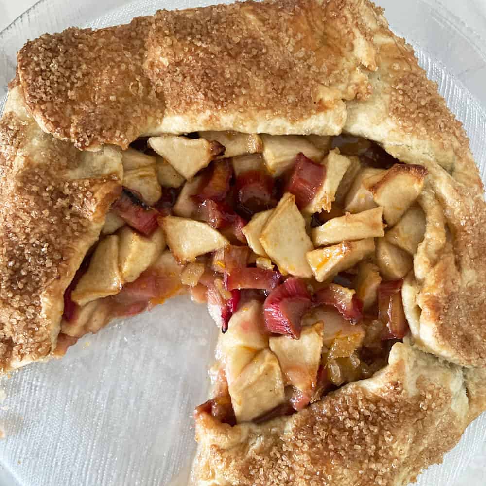 overhead of apple rhubarb galette with piece missing