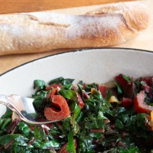 Swiss chard on fork with baguette in background