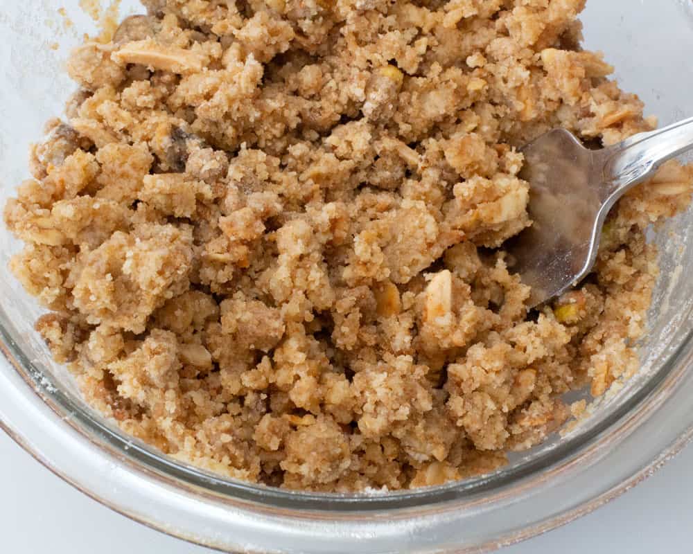 mixing melted butter into granola streusel