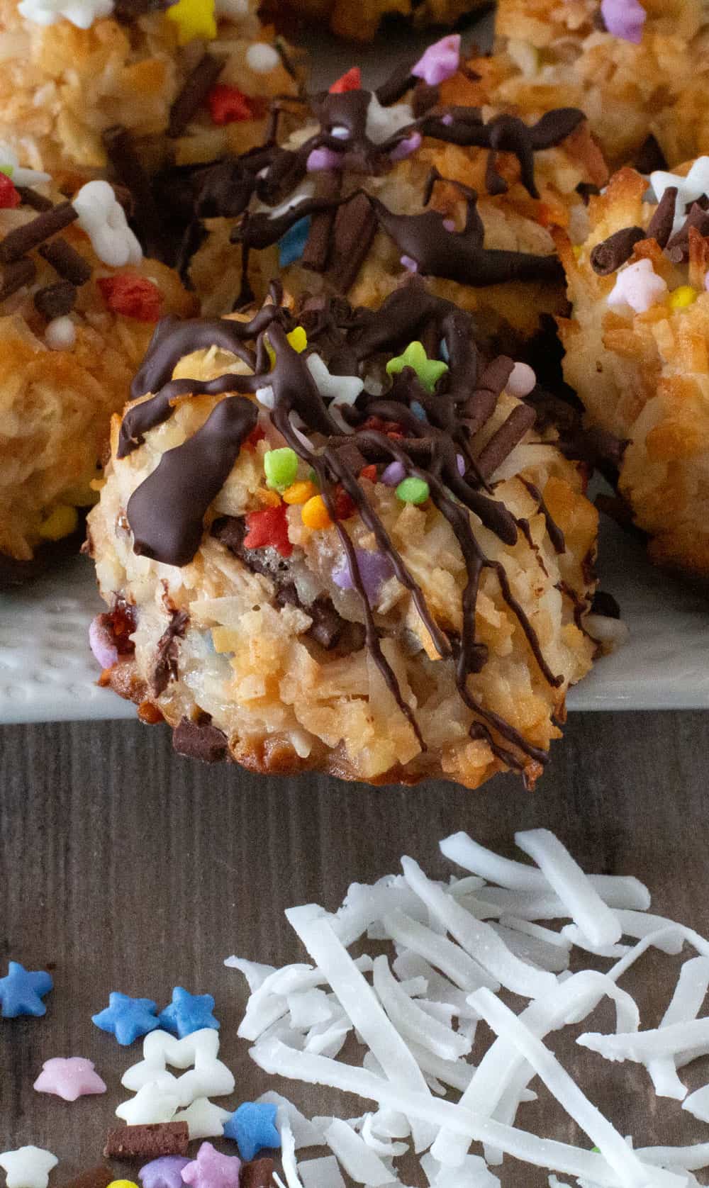 close-up of a colorful Passover coconut macaroon with sprinkles and coconut spread out in front 