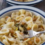 pasta with chickpeas & sage on a fork with bowl underneath