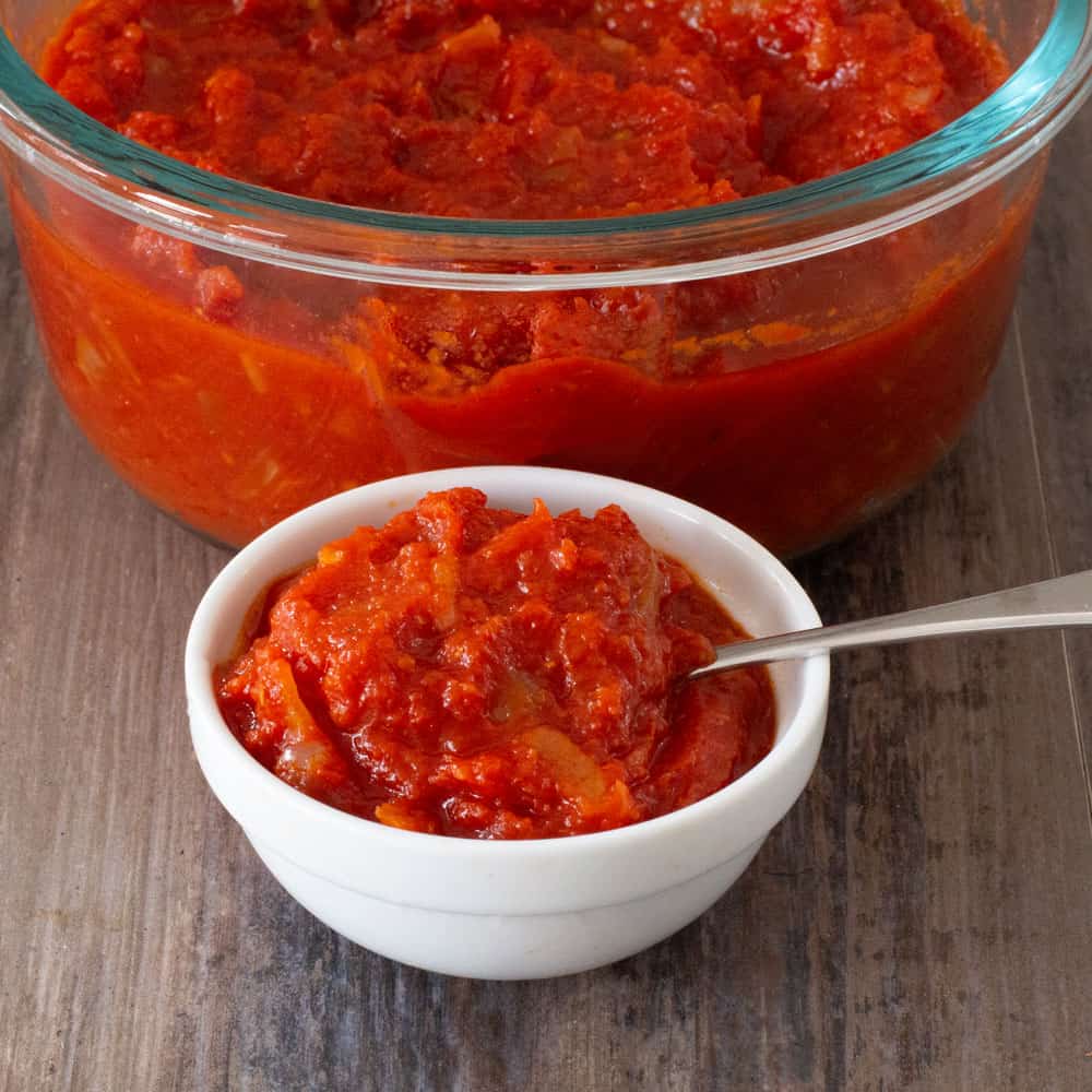 spicy red sauce (Arrabbiata) in small bowl with larger glass bowl of sauce in back 