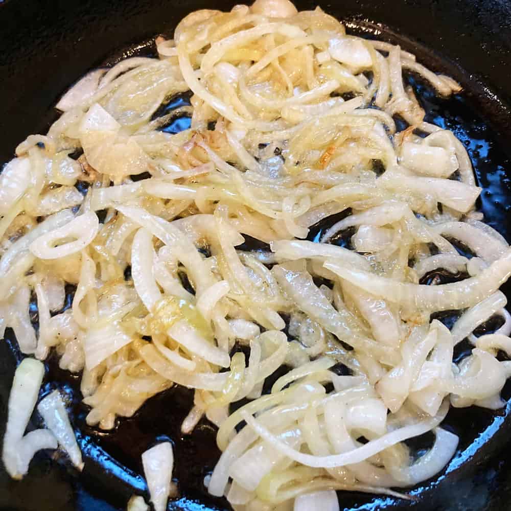 sliced onions cooking for savory noodle kugel