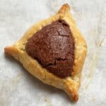 A closeup of Nutella-filled hamantaschen on parchment paper