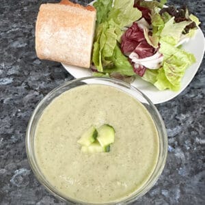 bowl of chilled cucumber soup with bread and salad