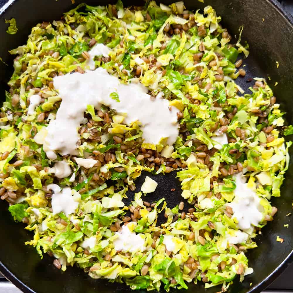 Adding tahini dressing to farro and Brussels sprouts 