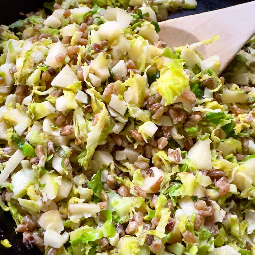 mixing everything together for farro with Brussels Sprouts with apple