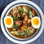 overhead of bowl of ramen with jammy egg halves on the side and tofu in the middle