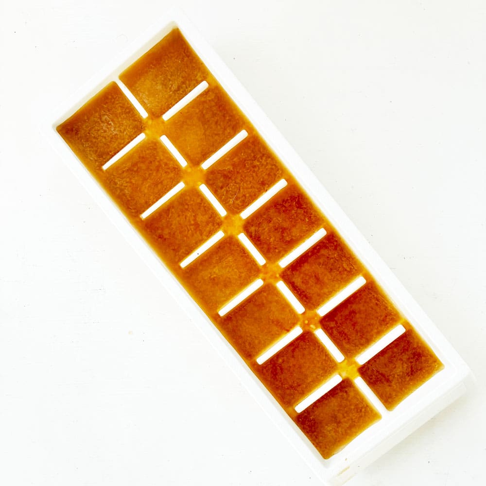 an ice cube tray filled with soup to freeze soup cubes